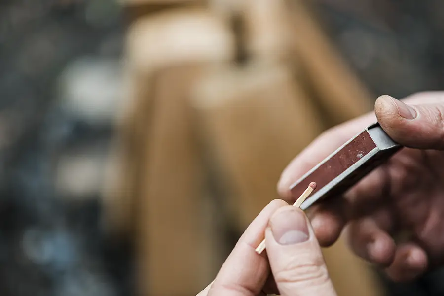 Imagen de una persona encendiendo un cerillo